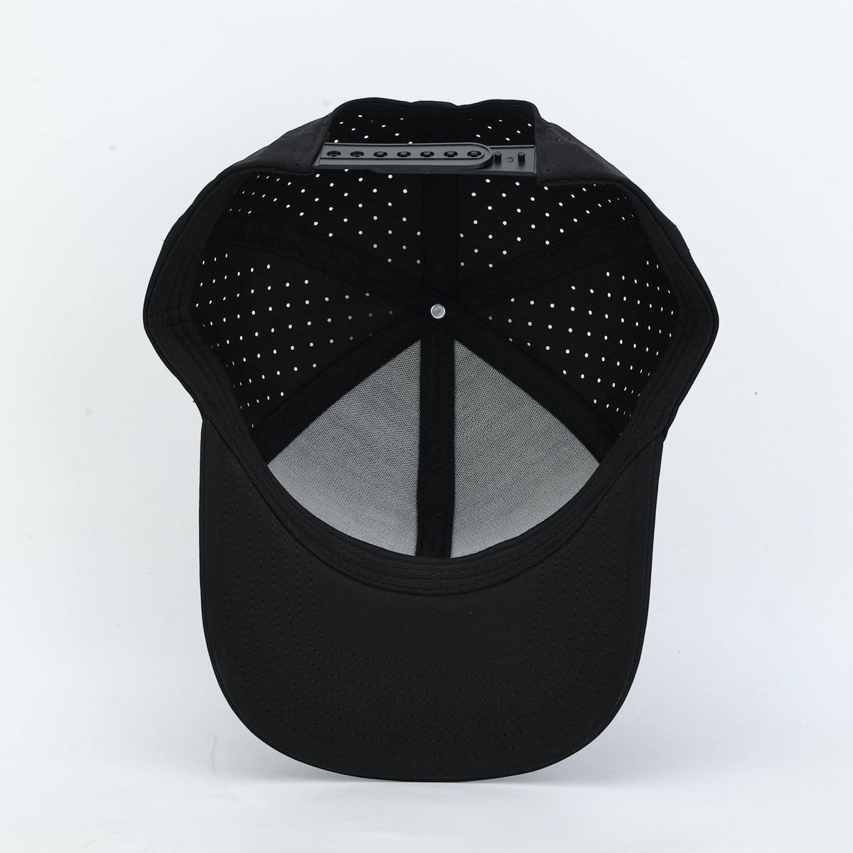 Relic Rove black baseball cap with laser-cut ventilation holes and adjustable snapback closure, interior view.